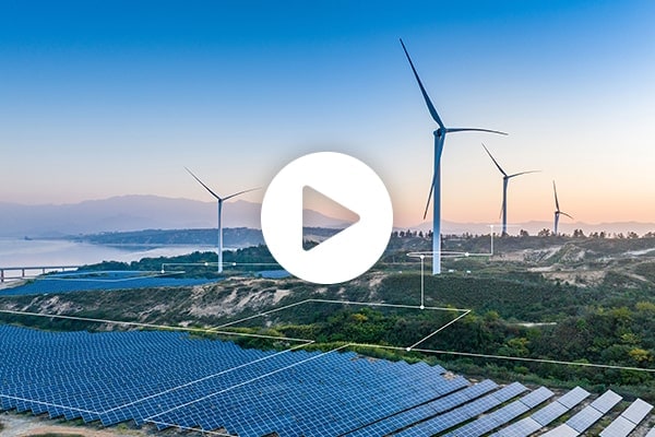A field of solar panels and wind turbines on a grid